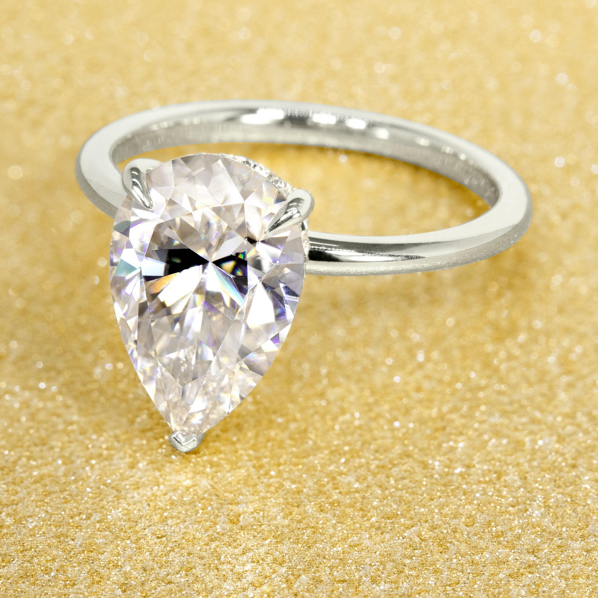 The Adara 3.5ct Pear-shaped Moissanite Hidden Halo Engagement Ring is a classic look with an elegant twist complemented by Lab Diamonds handcrafted in 14K Gold, 18K Gold, or Platinum by Earthena Jewelry of Beverly HIlls