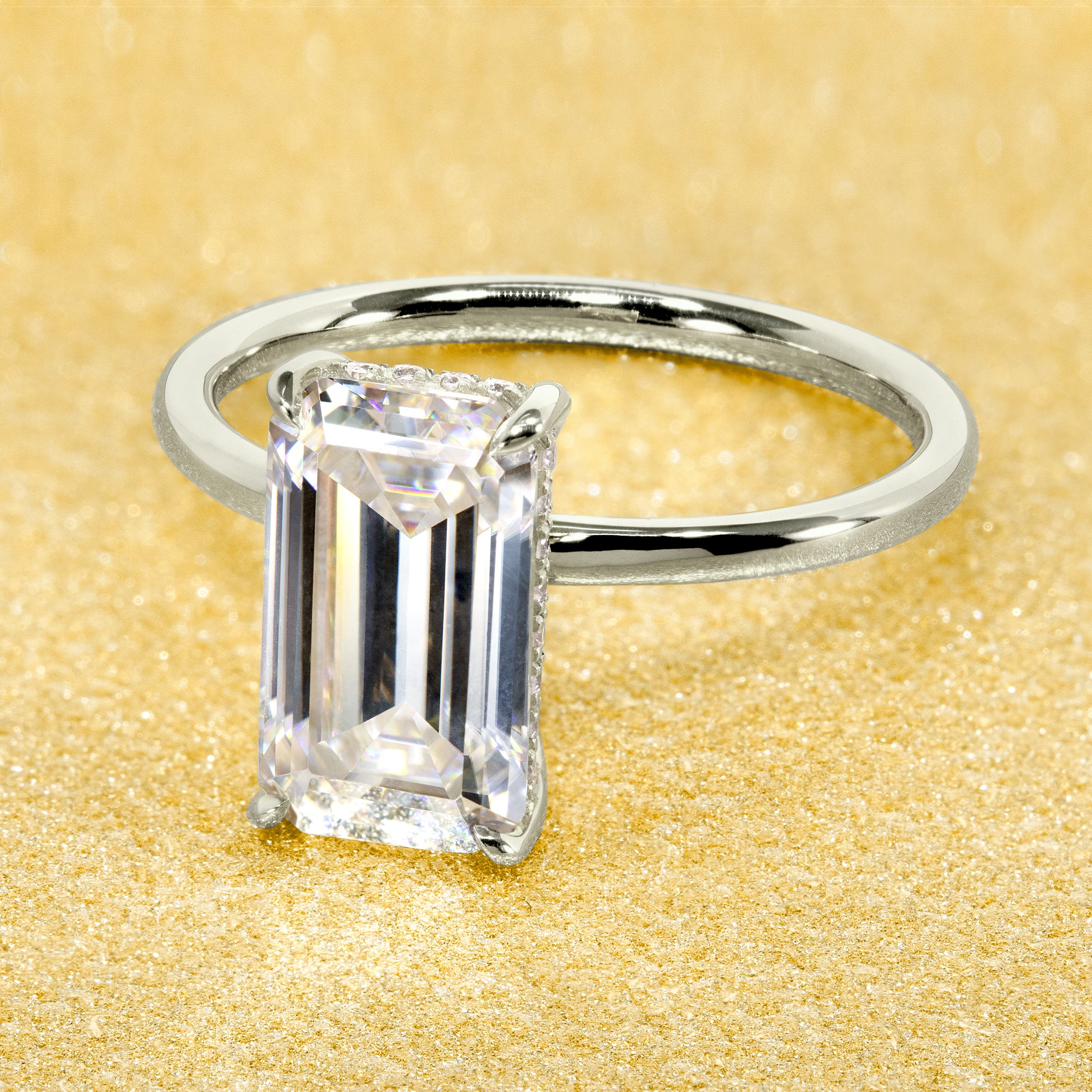 Classic Ariela 3ct Elongated Emerald-cut Moissanite Halo Solitaire Engagement ring complemented by Lab Diamonds handcrafted in 14K Gold, 18K Gold, or Platinum by Earthena Jewelry of Beverly Hills.