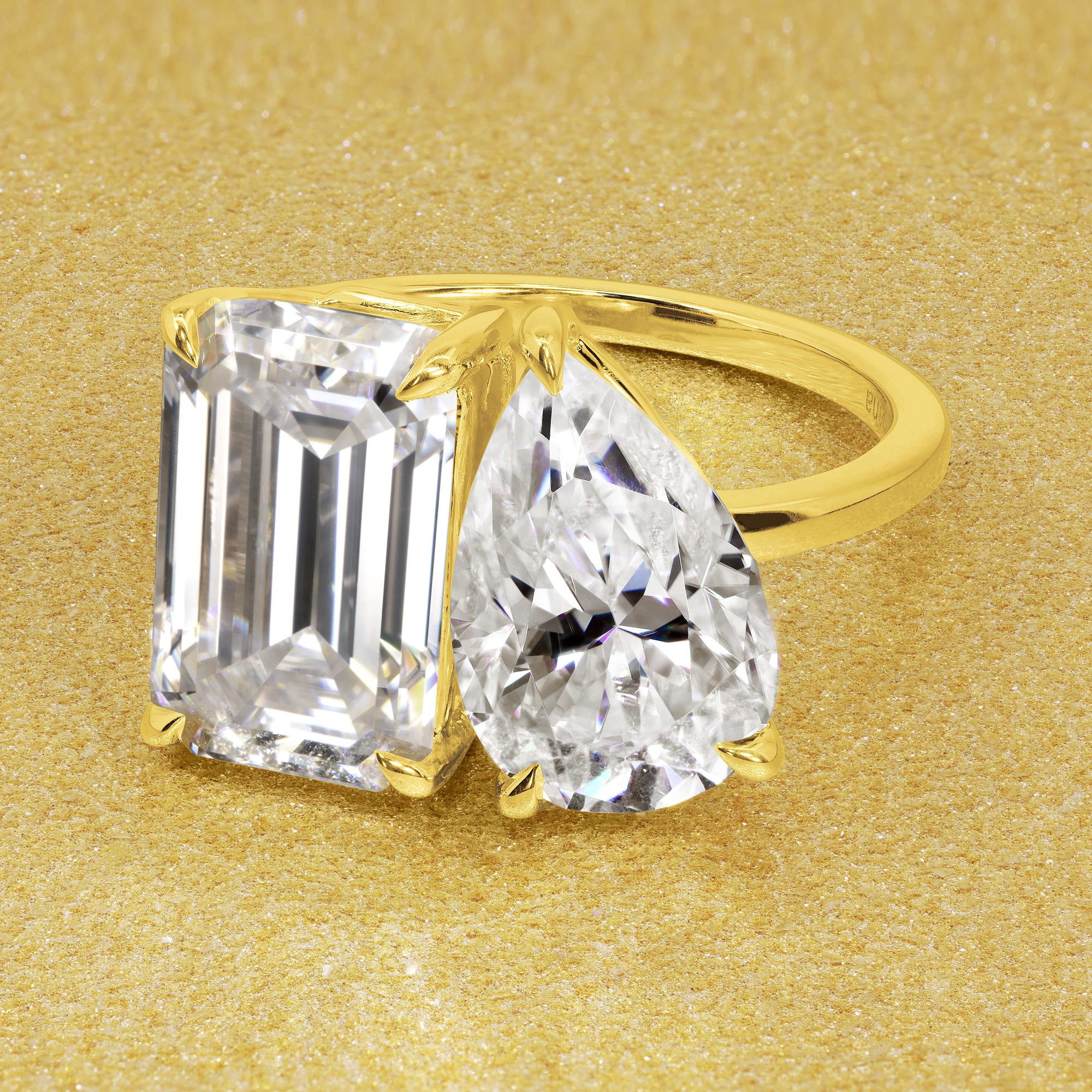 This timeless "Toi et Moi" Gemini Sleek engagement ring showcases a captivating combination of a 3.75ct elongated emerald cut and a 2.25ct pear-shaped moissanite in a minimalistic plain gold band setting. The ring is available in 14K Gold, 18K Gold, or Platinum by Earthena Jewelry of Beverly Hills.