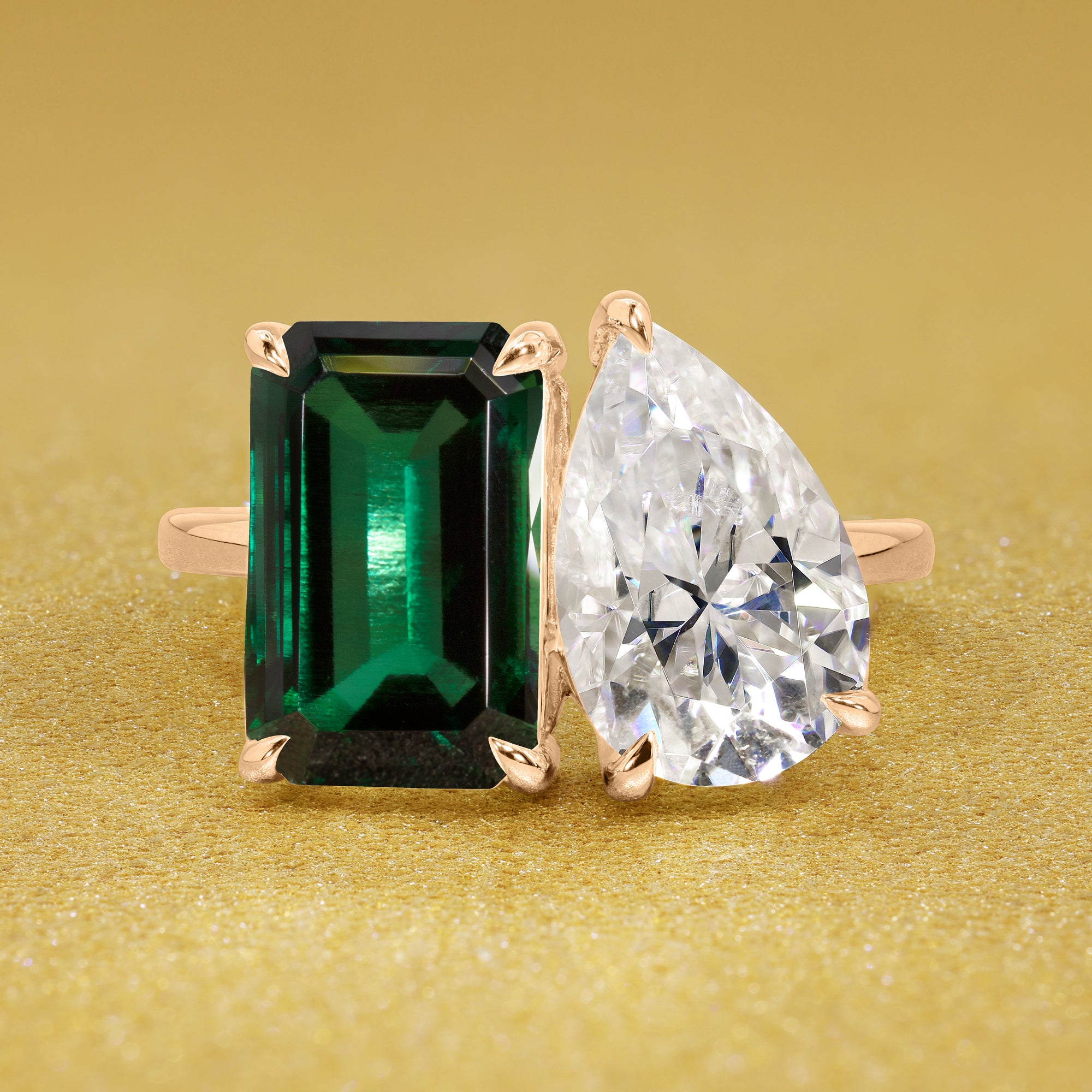 This timeless "Toi et Moi" Gemini Sleek engagement ring showcases a captivating combination of a 3.75ct lab-grown elongated green emerald and a 2.25ct pear-shaped moissanite in a minimalistic plain gold band setting. The ring is available in 14K Gold, 18K Gold, or Platinum by Earthena Jewelry of Beverly Hills.