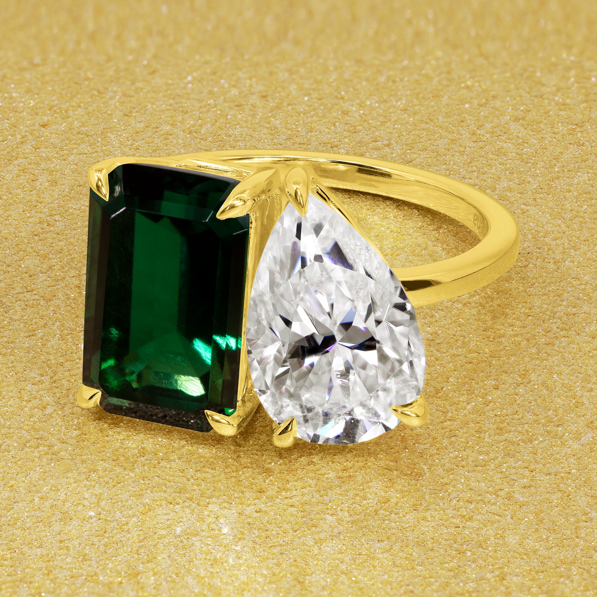 This timeless "Toi et Moi" Gemini Sleek engagement ring showcases a captivating combination of a 3.75ct lab-grown elongated green emerald and a 2.25ct pear-shaped moissanite in a minimalistic plain gold band setting. The ring is available in 14K Gold, 18K Gold, or Platinum by Earthena Jewelry of Beverly Hills.