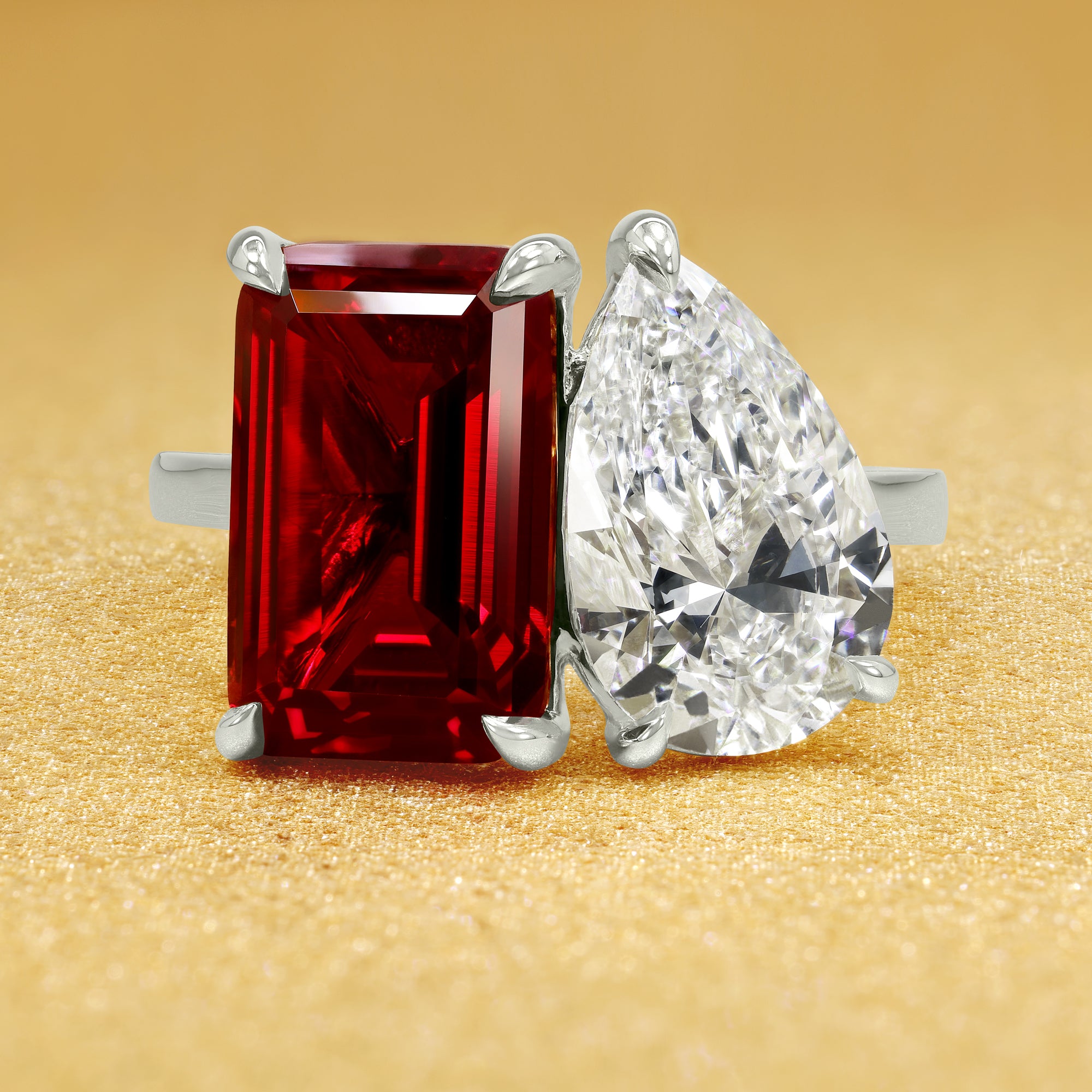 This timeless "Toi et Moi" Gemini Sleek cathedral engagement ring showcases a captivating combination of a 3.75ct lab-grown elongated emerald-cut ruby and a lab-grown 2ct pear-shaped diamond in a minimalistic plain gold band setting. The ring is available in 14K Gold, 18K Gold, or Platinum by Earthena Jewelry of Beverly Hills.