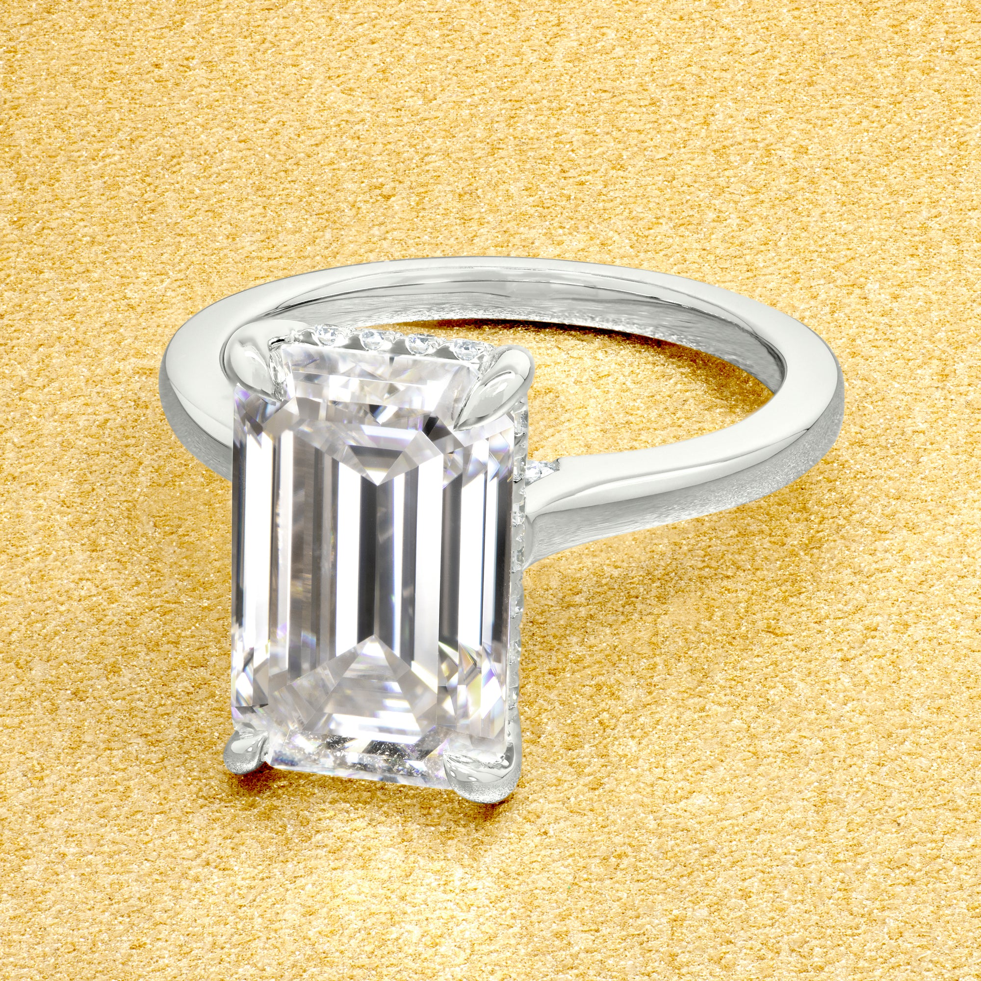 Classic Sofia 5ct Elongated Emerald-cut Moissanite Cathedral Hidden Halo Diamond Bridge Solitaire Engagement Ring in 14K Gold, 18K Gold, or Platinum by Earthena Jewelry of Beverly Hills.