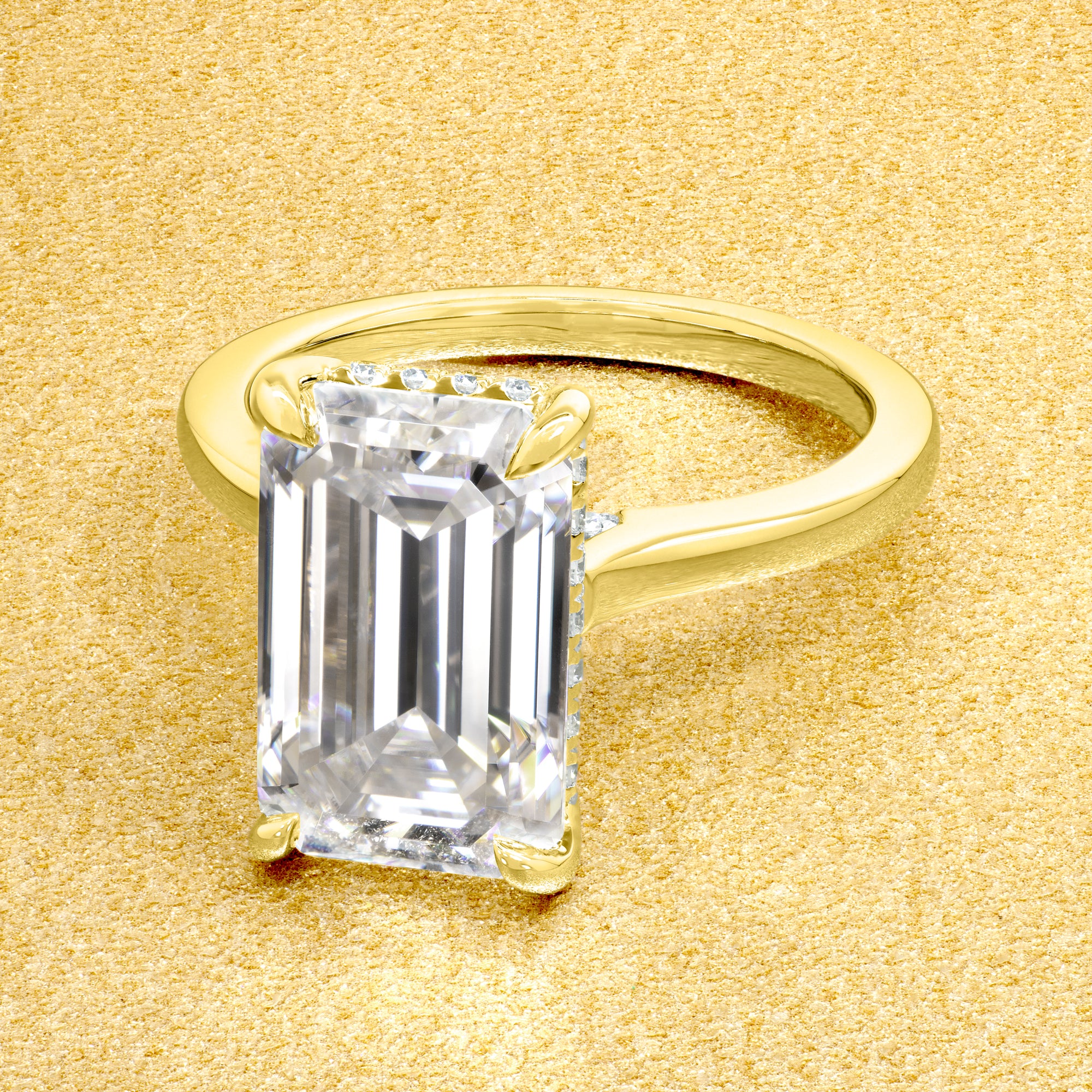 Classic Sofia 5ct Elongated Emerald-cut Moissanite Cathedral Hidden Halo Diamond Bridge Solitaire Engagement Ring in 14K Gold, 18K Gold, or Platinum by Earthena Jewelry of Beverly Hills.