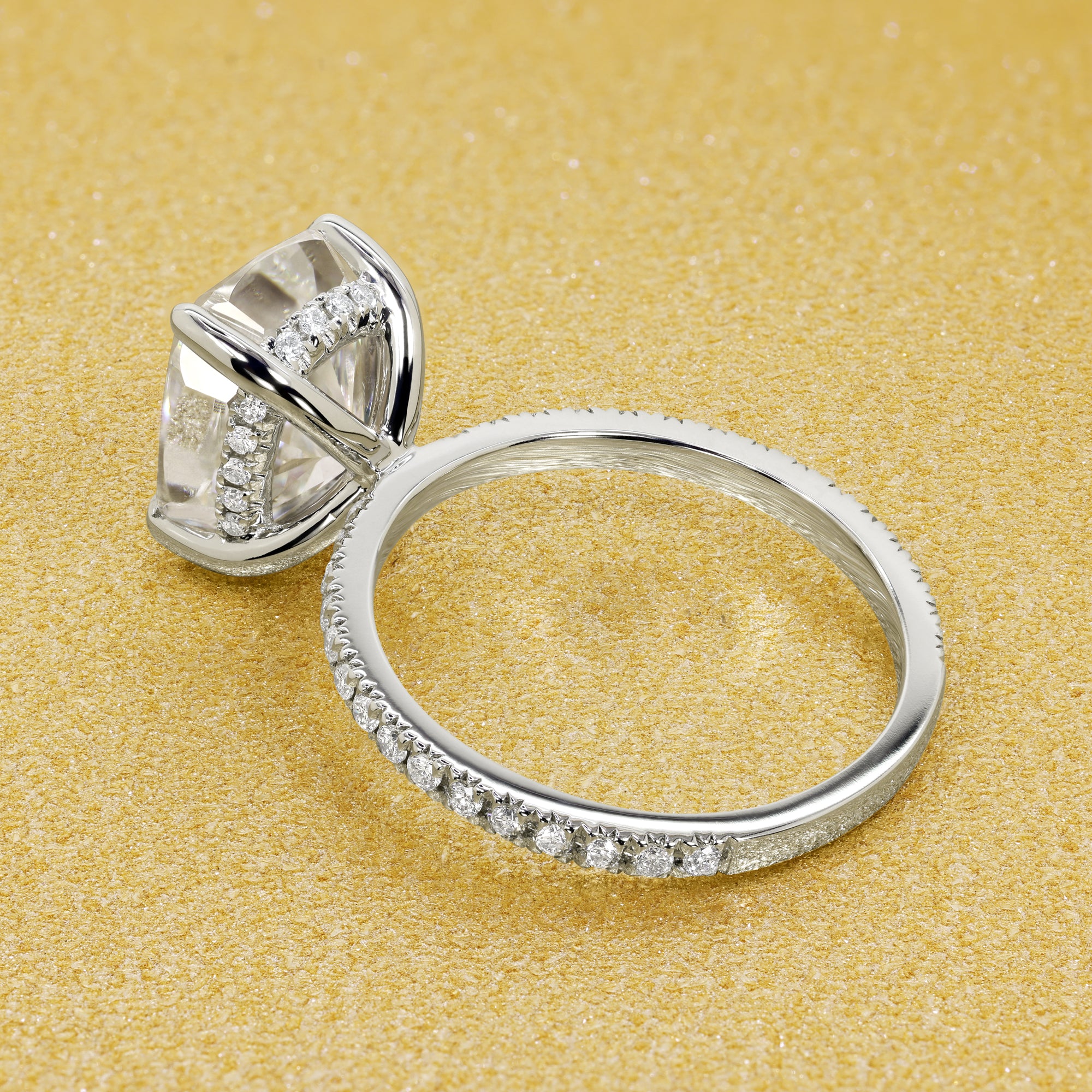 The Stella Elongated Brilliant-cut Cushion-cut Pave band Hidden Halo Moissanite Engagement Ring is a classic look with an elegant twist complemented by Moissanite stones handcrafted in 14K Gold, 18K Gold, or Platinum handcrafted in Los Angeles by Earthena Jewelry.