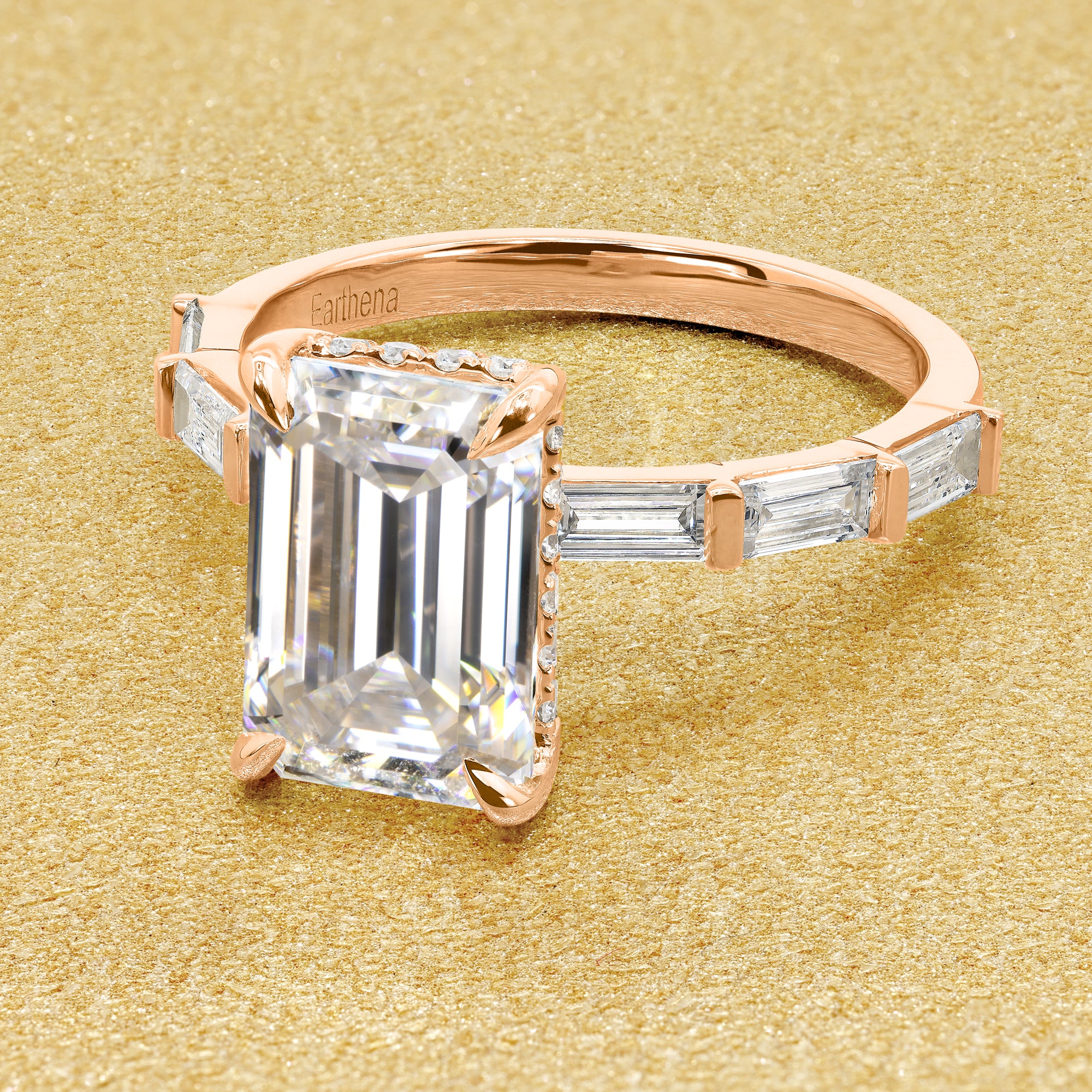 The Taylor 3ct elongated emerald-cut moissanite stone with lab-grown diamond accents set in 14K gold, 18K gold, or Platinum by Earthena Jewelry of Beverly Hills.