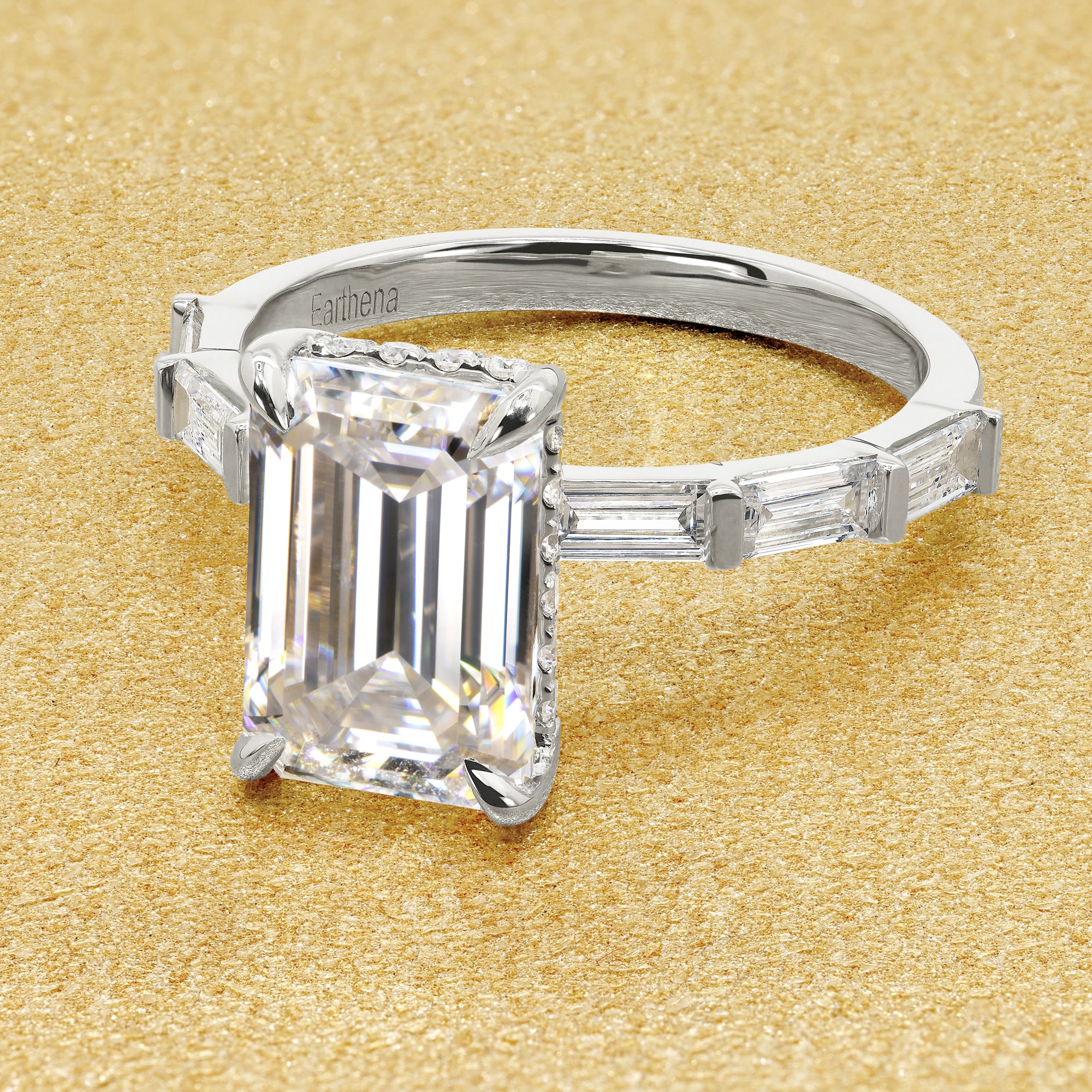 The Taylor 3ct elongated emerald-cut moissanite stone with lab-grown diamond accents set in 14K gold, 18K gold, or Platinum by Earthena Jewelry of Beverly Hills.
