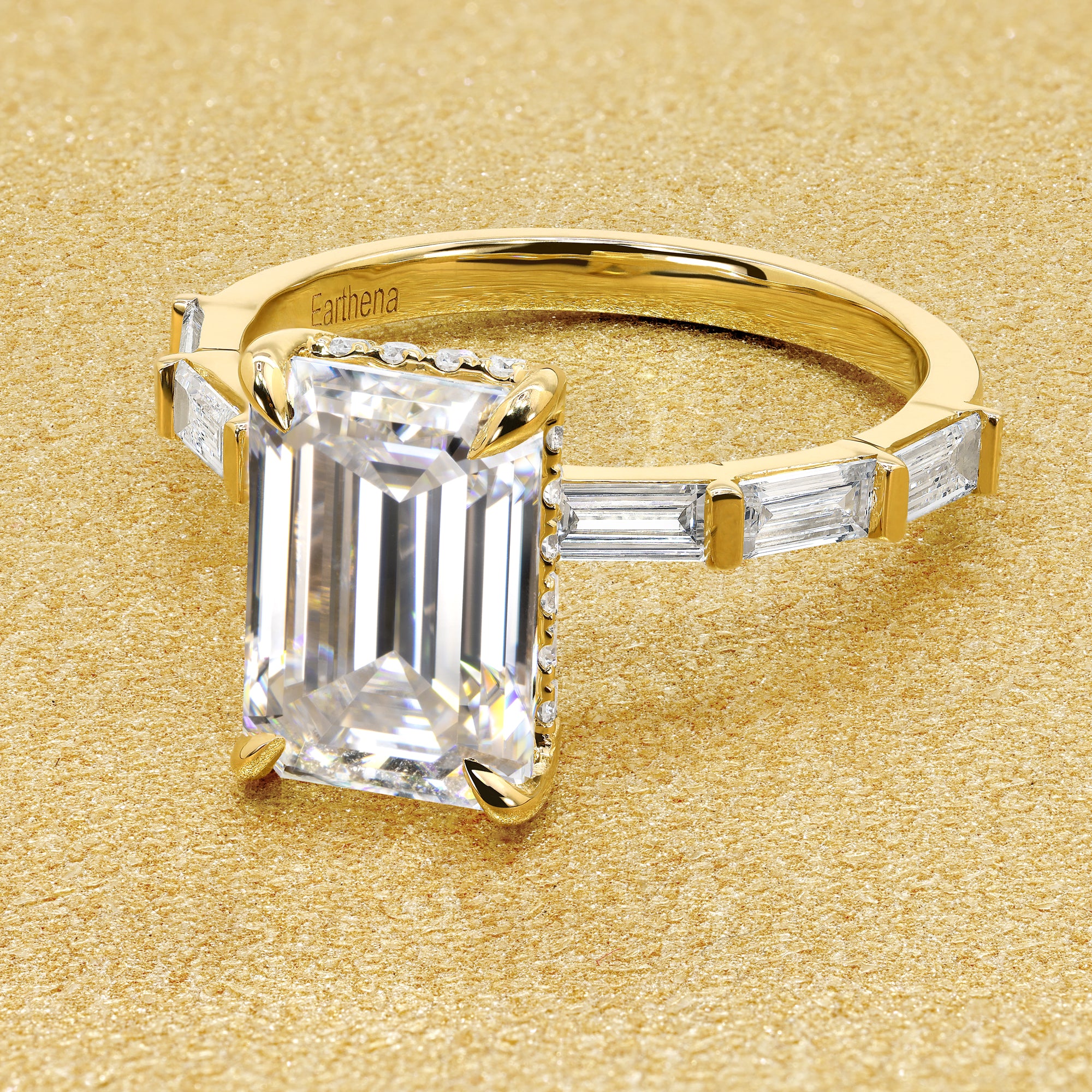 The Taylor 3ct elongated emerald-cut moissanite stone with lab-grown diamond accents set in 14K gold, 18K gold, or Platinum by Earthena Jewelry of Beverly Hills.