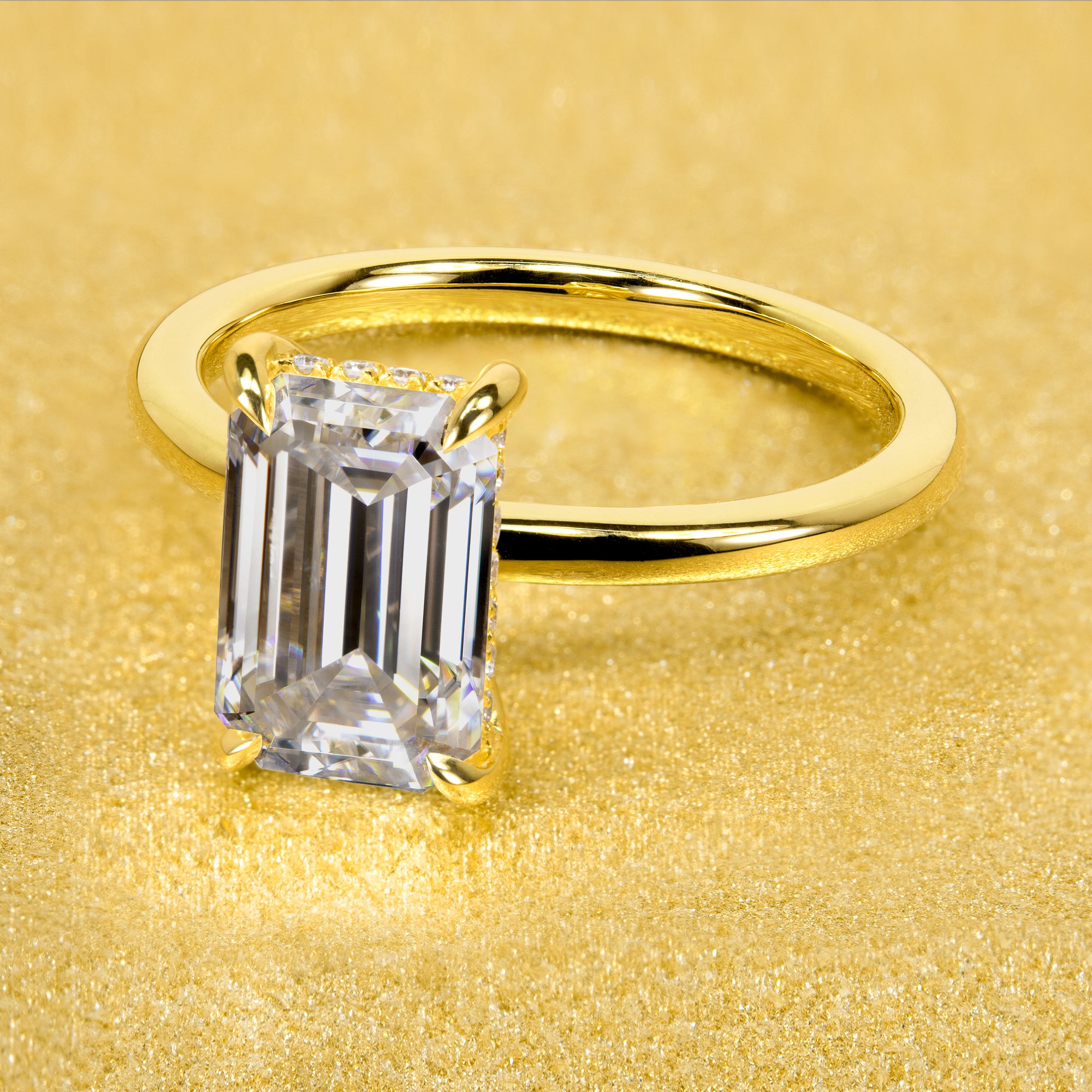 The Adara Elongated 3ct Emerald-cut Moissanite Hidden Halo Engagement Ring is a classic look with an elegant twist complemented by Lab Diamonds handcrafted in 14K Gold, 18K Gold, or Platinum by Earthena Jewelry of Beverly Hills.