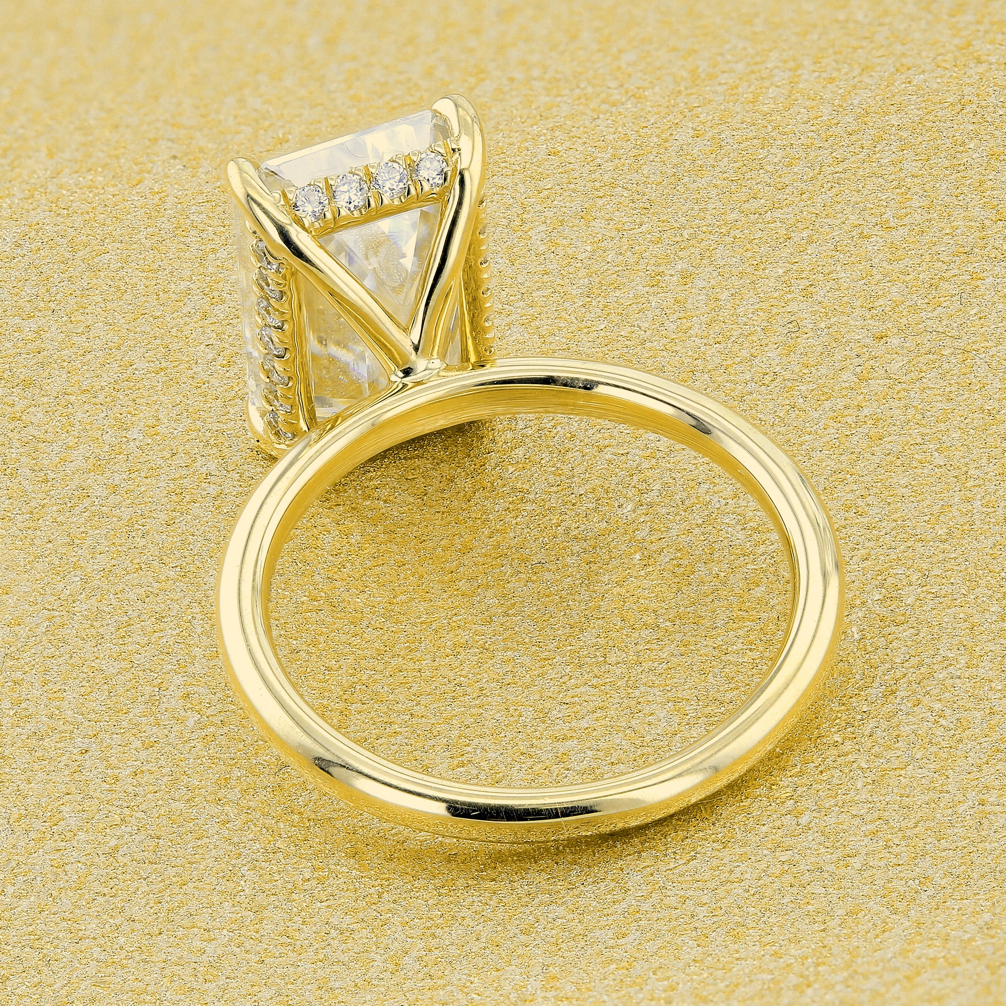 Classic Ariela 5.5ct Elongated Emerald-cut Moissanite Halo Solitaire Engagement ring complemented by Lab Diamonds handcrafted in 14K Gold, 18K Gold, or Platinum by Earthena Jewelry of Beverly Hills.