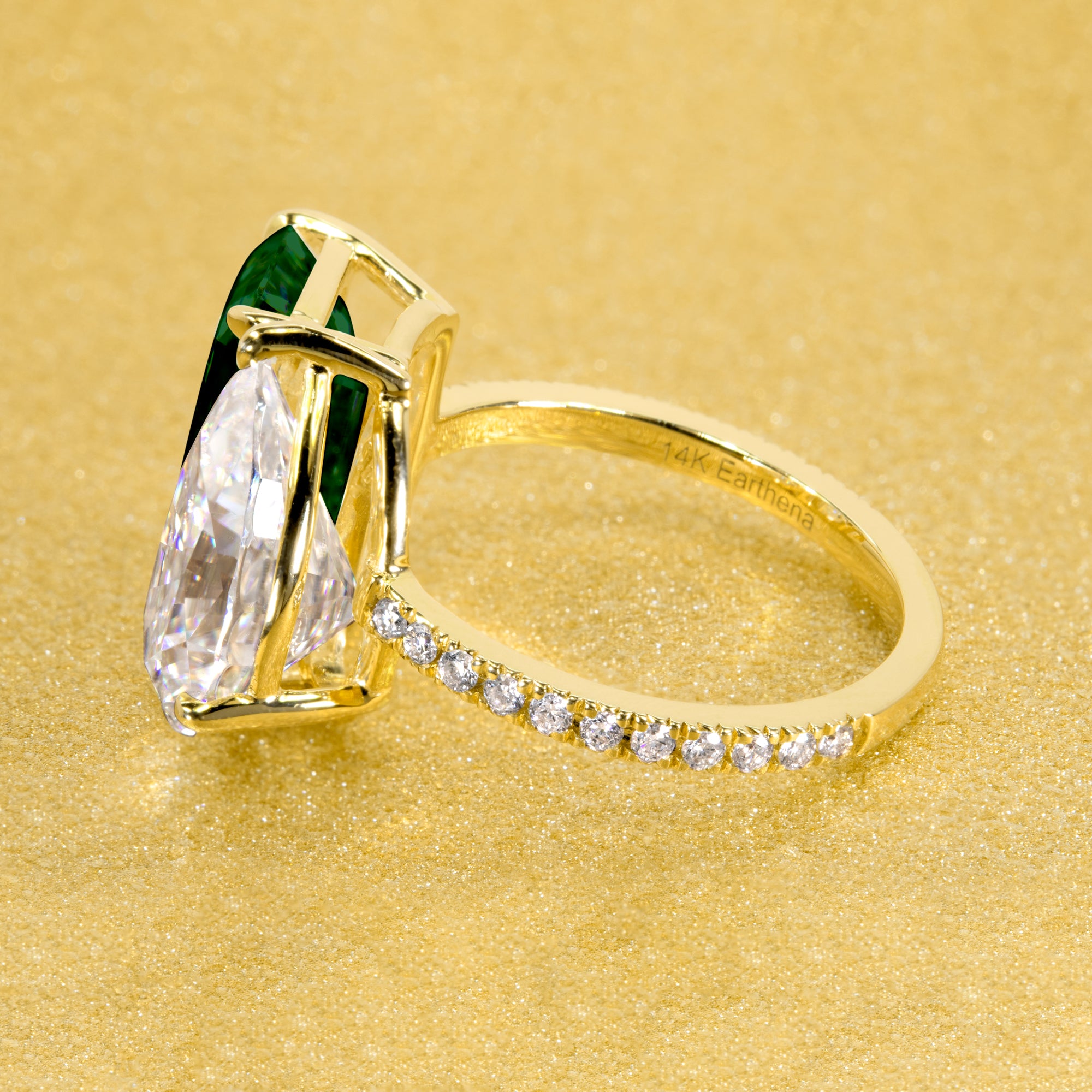 This timeless "Toi et Moi" Gemini engagement ring showcases a captivating combination of a 3.75ct lab-grown elongated green emerald and a 2.25ct pear-shaped moissanite, styled with lab-grown side diamonds. The ring is available in 14K Gold, 18K Gold, or Platinum by Earthena Jewelry of Beverly Hills.