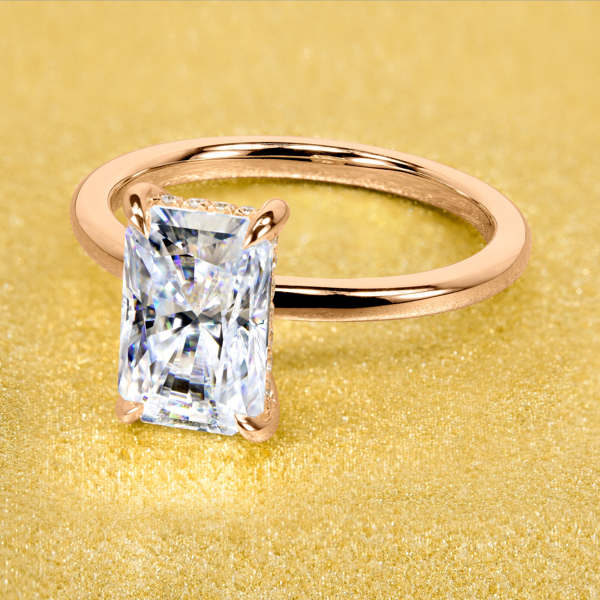 The Adara Elongated 3ct Radiant-cut Moissanite Hidden Halo Engagement Ring is a classic look with an elegant twist complemented by Lab Diamonds handcrafted in 14K Gold, 18K Gold, or Platinum by Earthena Jewelry of Beverly HIlls.