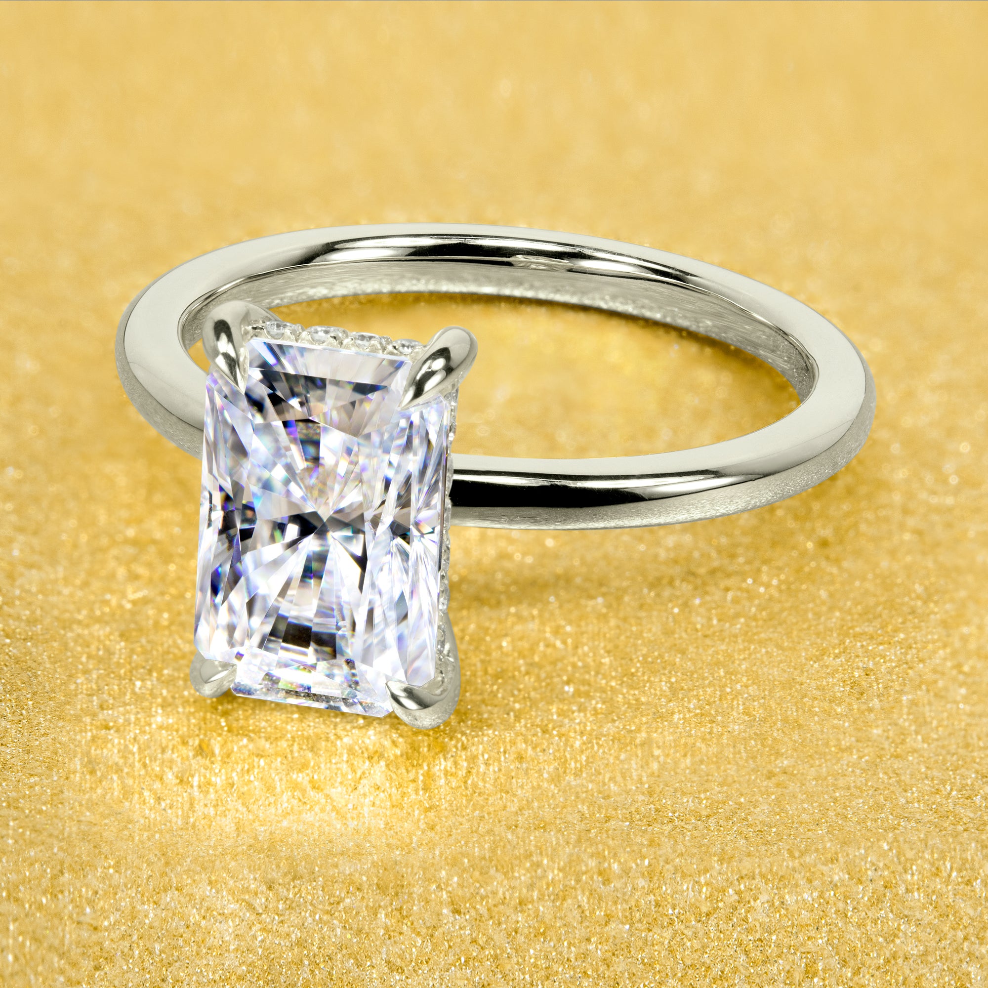 The Adara Elongated 3ct Radiant-cut Moissanite Hidden Halo Engagement Ring is a classic look with an elegant twist complemented by Lab Diamonds handcrafted in 14K Gold, 18K Gold, or Platinum by Earthena Jewelry of Beverly HIlls.