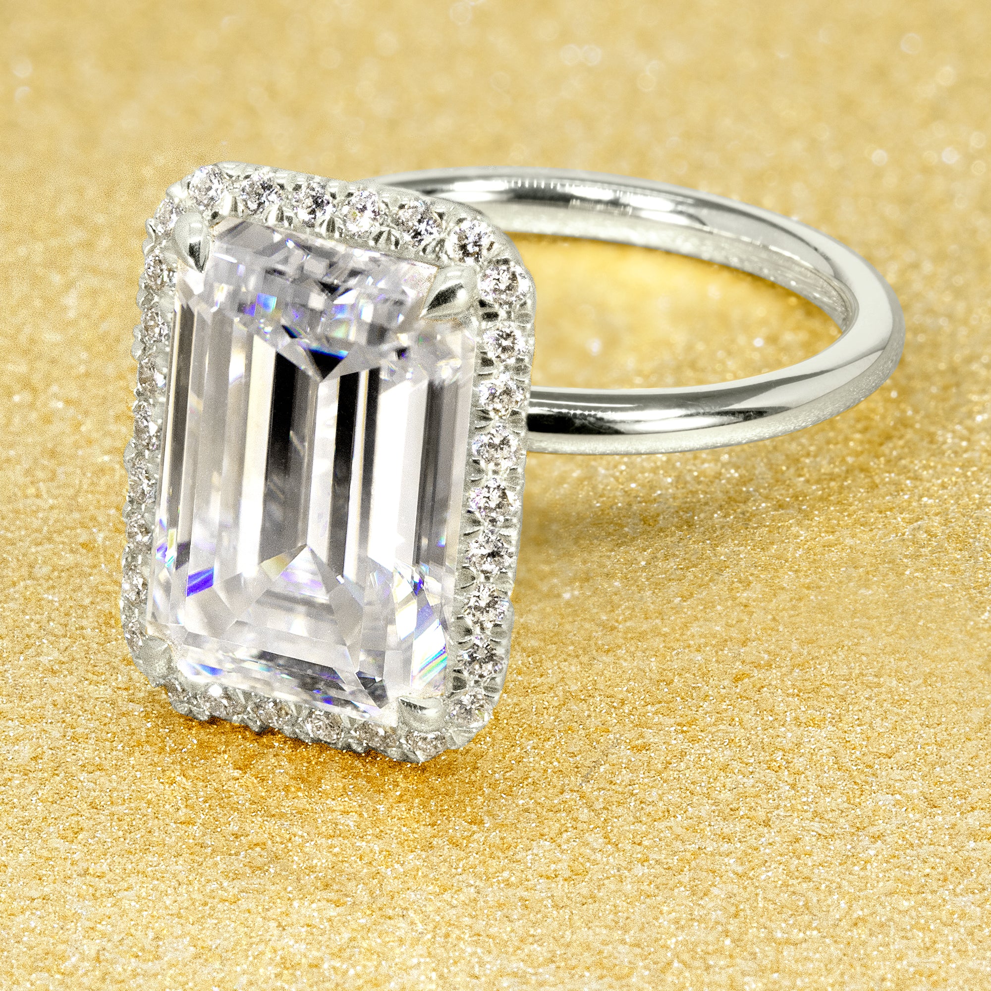 The Adara Elongated Emerald-cut Moissanite Halo Engagement Ring has a classic look with an elegant twist complemented by Lab Diamonds handcrafted in 14K Gold, 18K Gold, or Platinum by Earthena Jewelry of Beverly Hills.