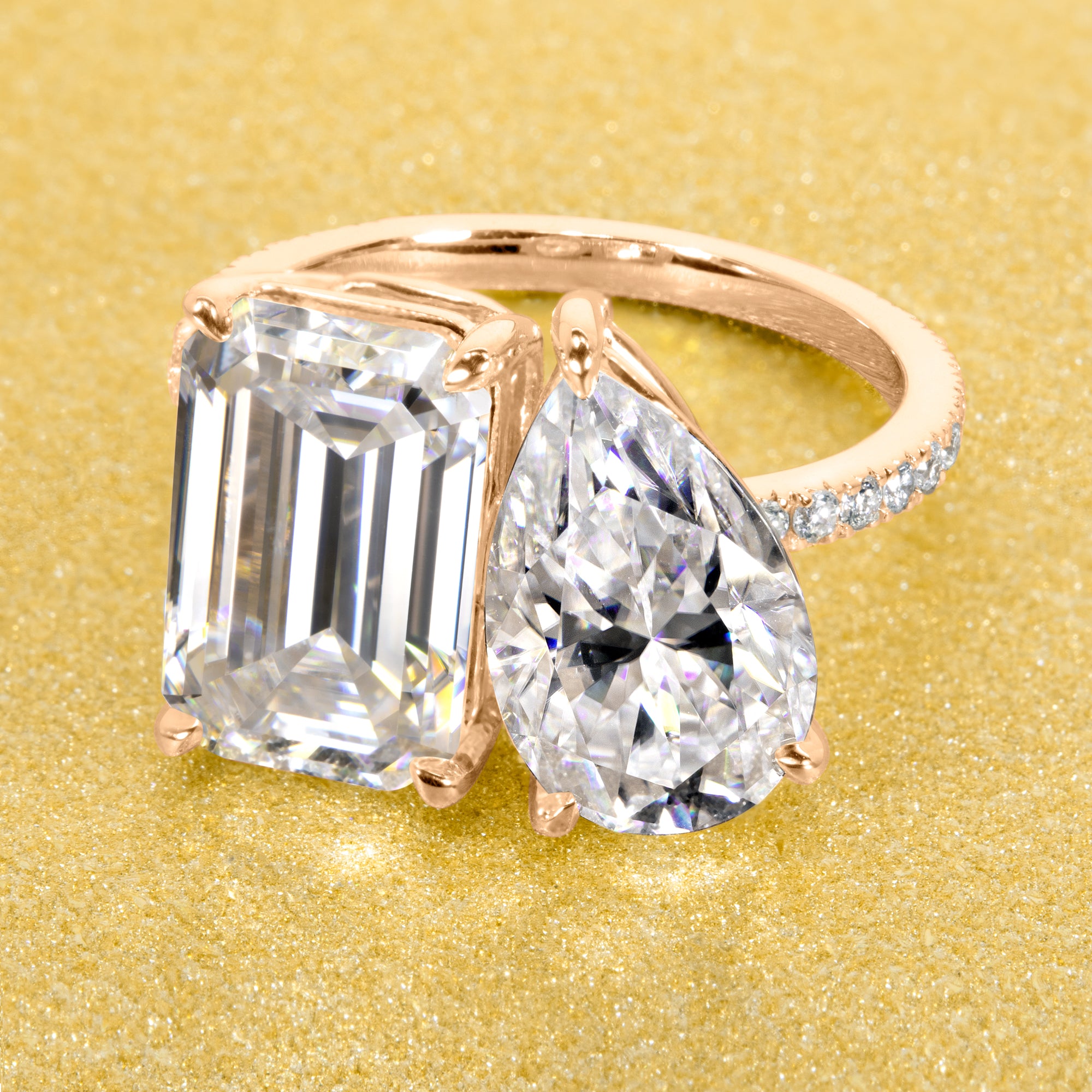 This timeless "Toi et Moi" Gemini engagement ring showcases a captivating combination of a 3.75ct elongated emerald cut and a 2.25ct pear-shaped moissanite, styled with lab-grown side diamonds. The ring is available in 14K Gold, 18K Gold, or Platinum by Earthena Jewelry of Beverly Hills.