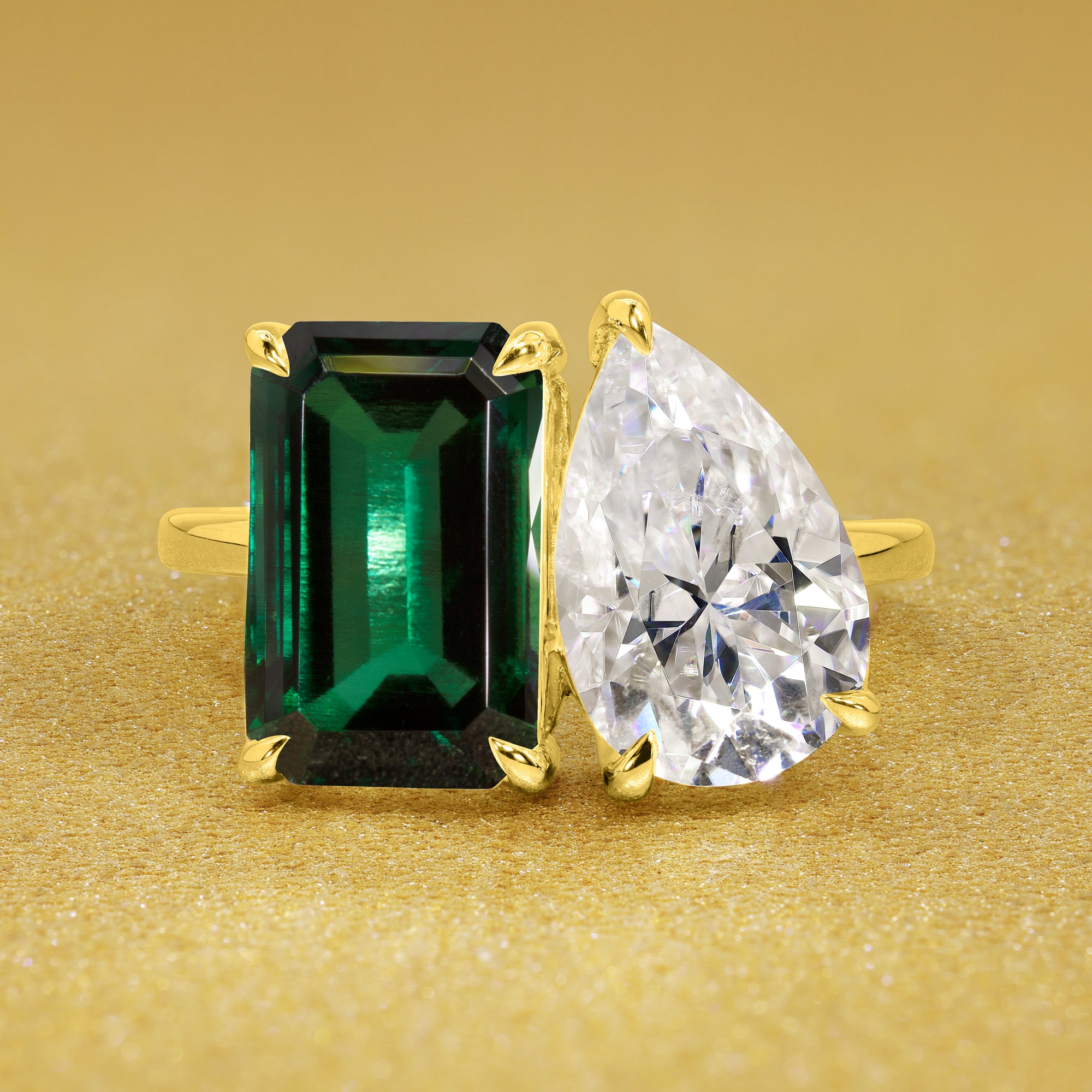 This timeless "Toi et Moi" Gemini Sleek engagement ring showcases a captivating combination of a 3.75ct lab-grown elongated green emerald and a 2.25ct pear-shaped moissanite in a minimalistic plain gold band setting. The ring is available in 14K Gold, 18K Gold, or Platinum by Earthena Jewelry of Beverly Hills.