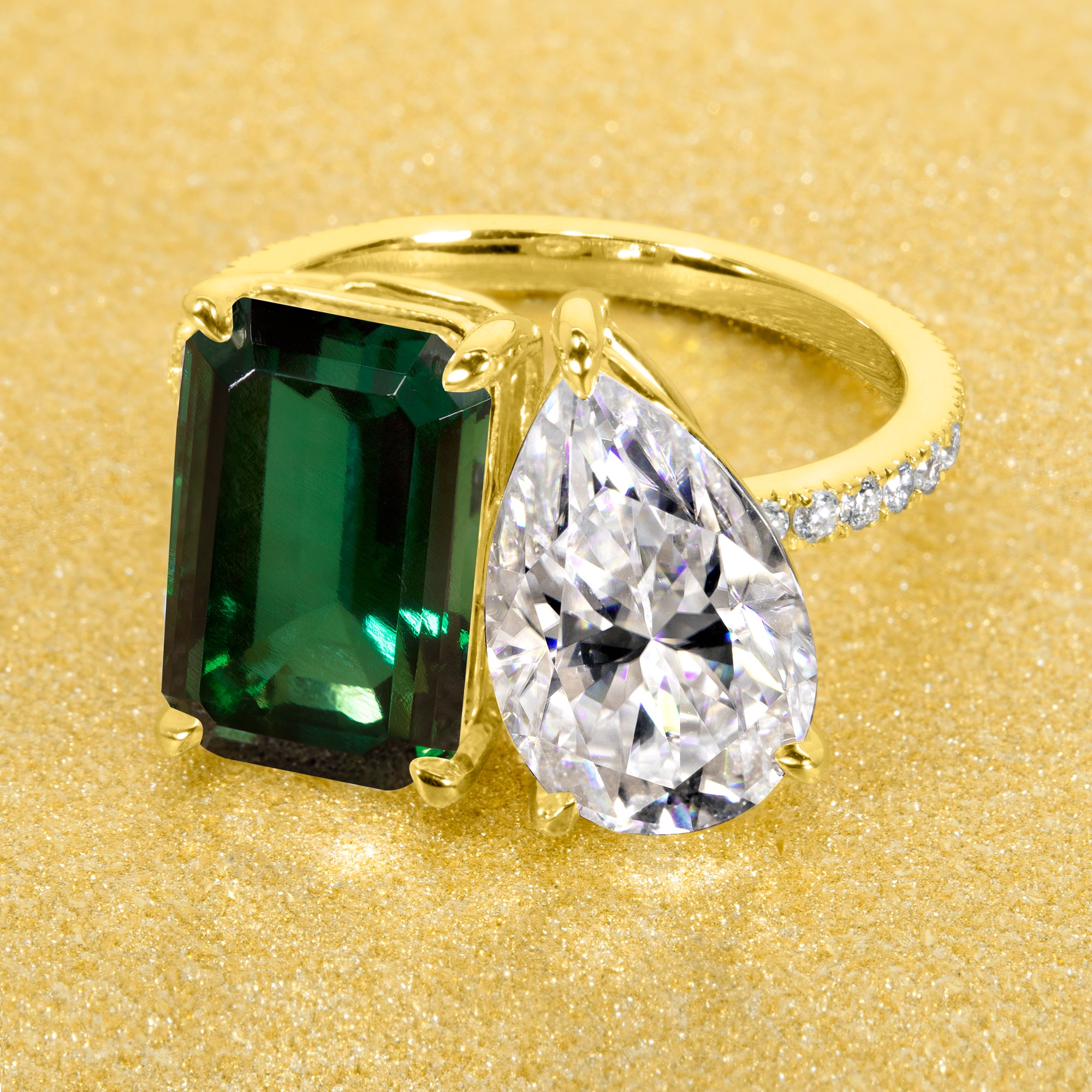 This timeless "Toi et Moi" Gemini engagement ring showcases a captivating combination of a 3.75ct lab-grown elongated green emerald and a 2.25ct pear-shaped moissanite, styled with lab-grown side diamonds. The ring is available in 14K Gold, 18K Gold, or Platinum by Earthena Jewelry of Beverly Hills.