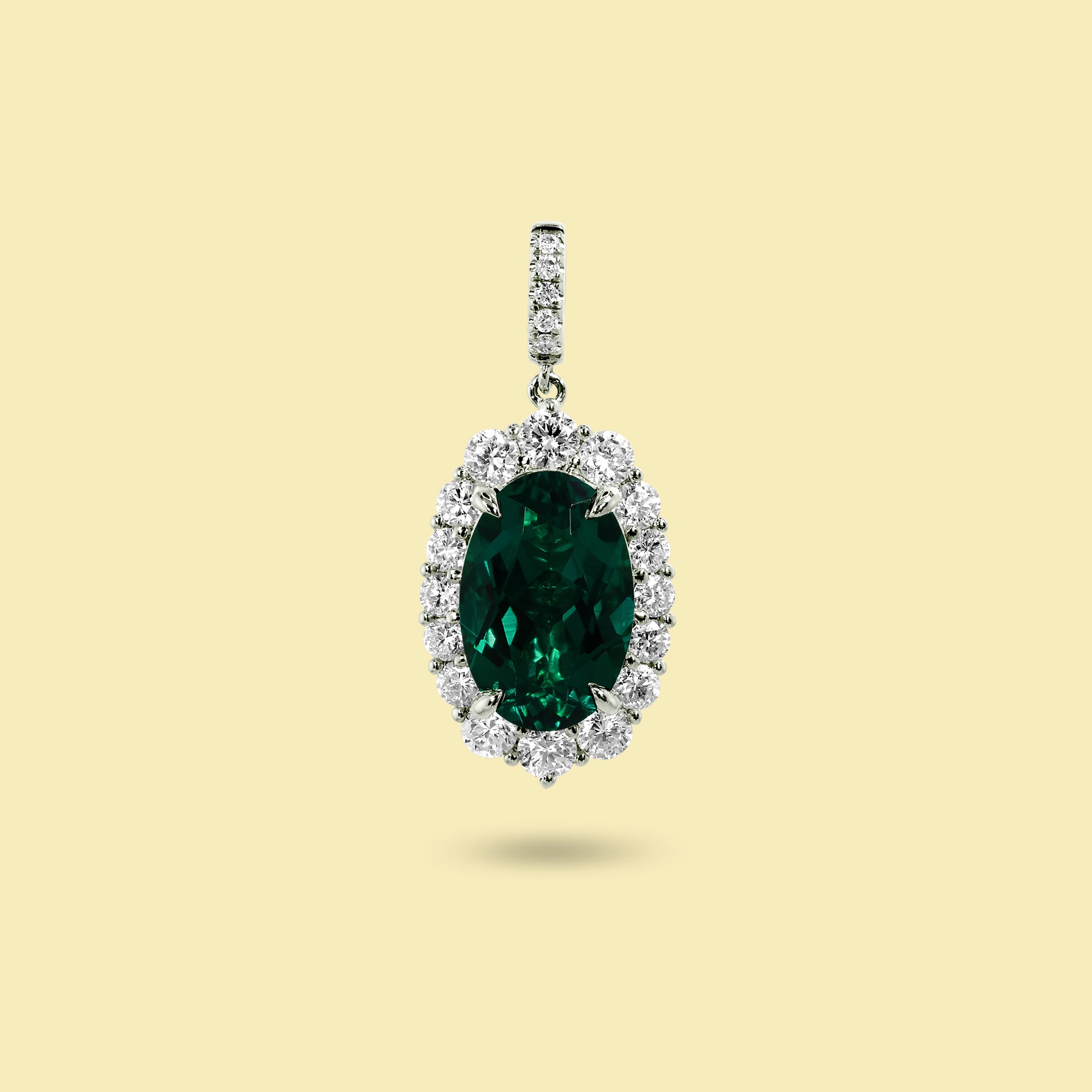 Gloria 3ct Oval-Cut Zambian Green Lab-Grown Emerald Halo Charm Pendant in 14K Gold, 18K Gold, or Platinum by Earthena Jewelry of Beverly Hills.